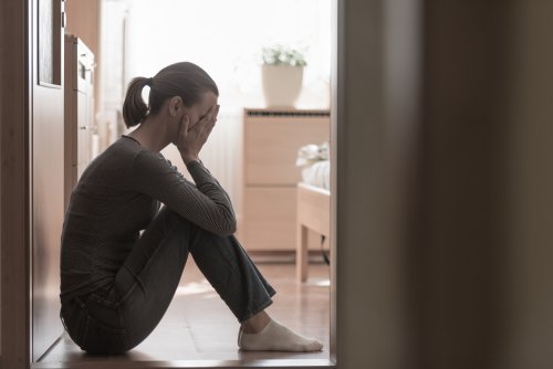 Mujer sentada en el suelo con depresión materna.