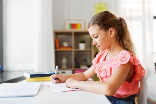 Niña haciendo deberes en un buen lugar de estudio en su habitación.