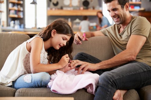 Niña pintándole las uñas a su padre.