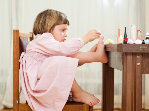 Niña pintándose las uñas debido al aprendizaje social.
