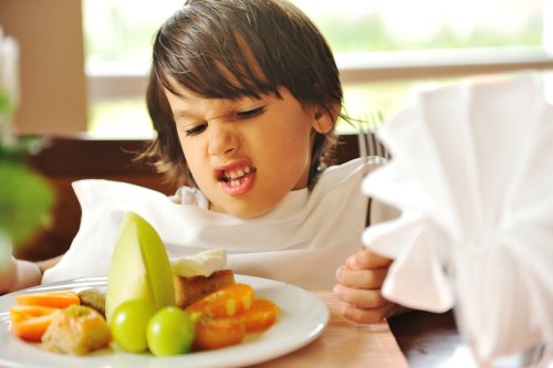 Niño al que no le gusta la comida de su plato.