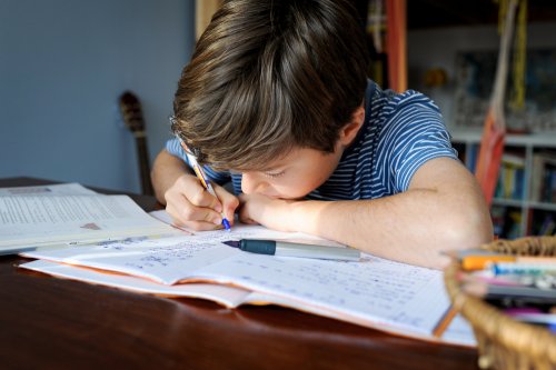 Niño haciendo ejercicios de hiatos y diptongos en su habitación.