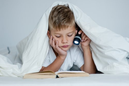 Niño estudiando en la cama, uno de los peores hábitos de estudio.