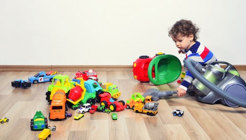 Niño con todos sus juguetes por el suelo sin ordenar.
