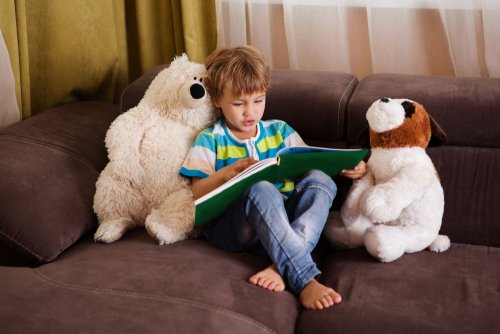 Niño leyendo libros infantiles a sus peluches para dar la bienvenida al invierno.