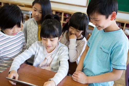 Bambini in classe con un tablet che studiano con il metodo di apprendimento onnipresente.