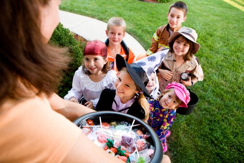 Niños pidiendo caramelos en una casa por Halloween.
