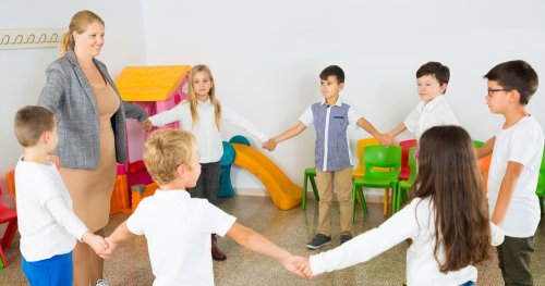 Niños haciendo pausas activas en clase agarrados de la mano formando un círculo.