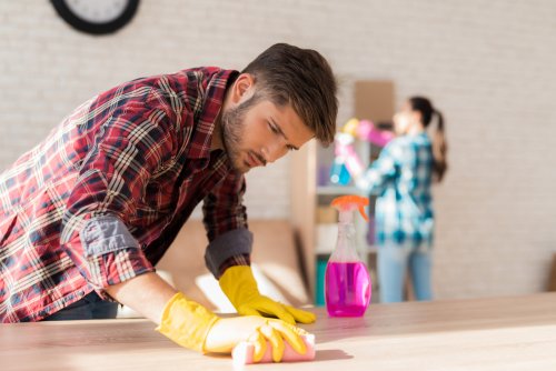 Pareja limpiando la casa juntos para reducir la carga mental de la mujer.