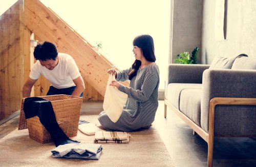 Pareja haciendo las tareas del hogar juntos para rebajar la carga mental de las mujeres.
