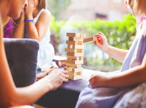 Familia jugando al Jenga, uno de los juegos de mesa para mejorar la atención.