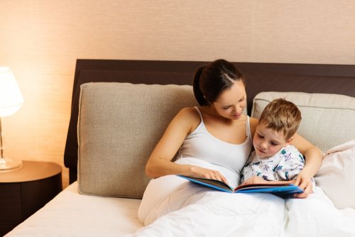 Madre leyendo un cuento a su hijo en la cama.