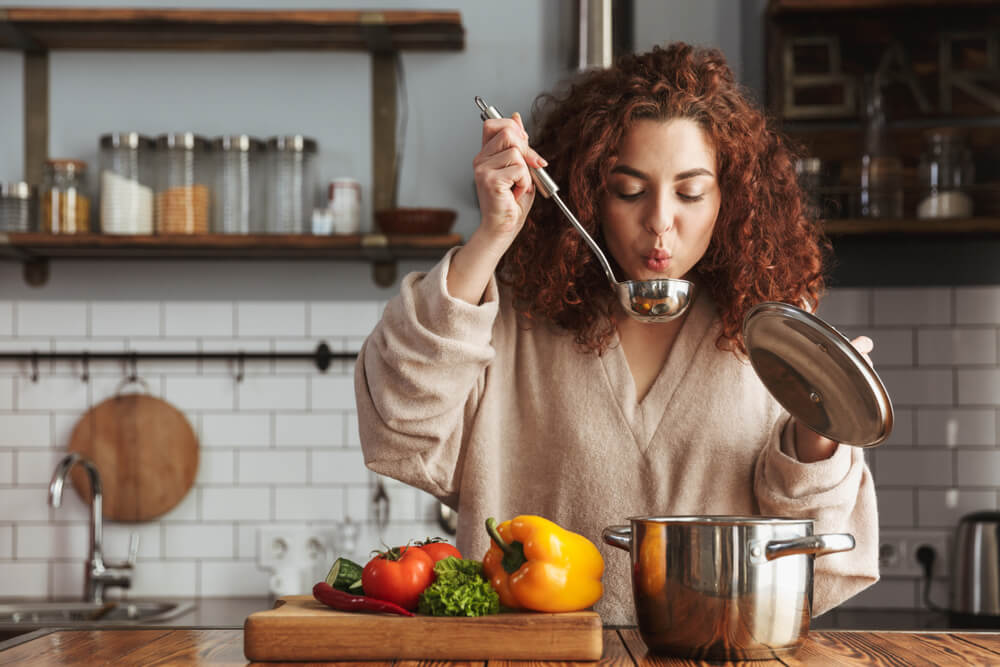 Femme dans la cuisine faisant des crèmes et des soupes très réconfortantes pour l'hiver.