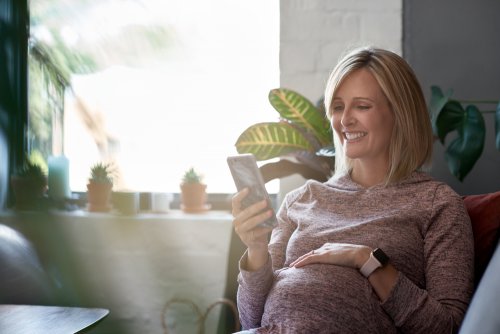 Mujer embarazada investigando sobre las diferentes Apps para mamás que existen.