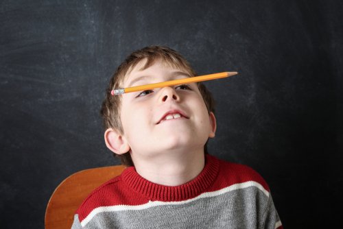Niño con un lápiz sobre la nariz al que habría que hacerle pruebas para evaluar su atención.