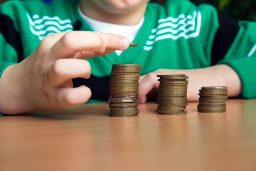 Niño contando el dinero que tiene para aprender a ahorrar.