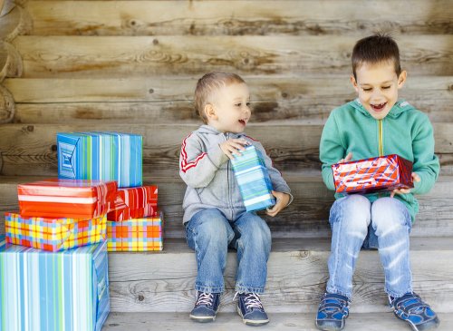 Niños abriendo regalos solidarios en Navidad.