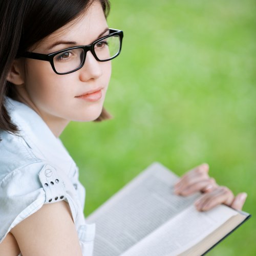 Adolescente leyendo al aire libre.