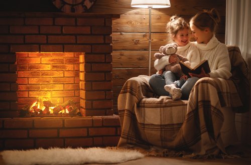 Madre leyendo libros infantiles a su hija para dar la bienvenida al invierno.