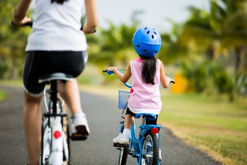 Mamá con su hija montando en bici.