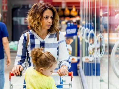 Mamá haciendo la compra en el supermercado con su hija.