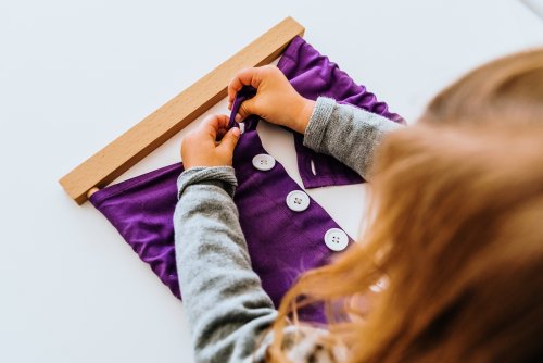 Niña aplicando la pedagogía Montessori para su desarrollo.