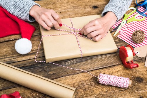 Mujer envolviendo libros infantiles para regalar en Navidad.