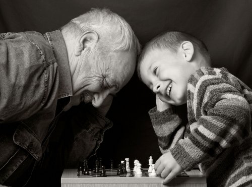 Niño jugando al ajedrez con su abuelo.