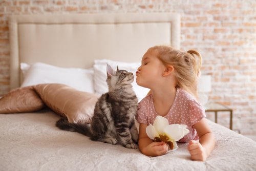 Niña dando un beso a su gato tras la adopción. 