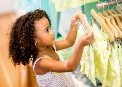 Niña comprando ropa.