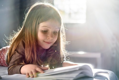 Niña leyendo libros para niños de 4 y 5 años.