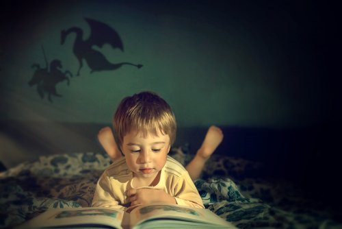 Niño leyendo un libro sobre dragones y princesas.