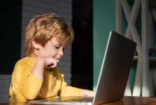 Niño estudiando con el ordenador en casa.