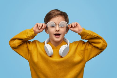 Niño sorprendido quitándose las gafas.
