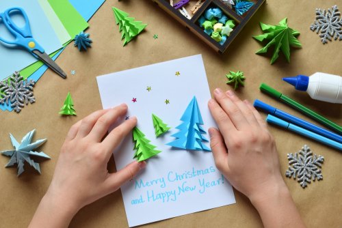 Decorando las tarjetas de Navidad con árboles hechos con cartulina.