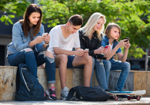 Adolescentes mirando el móvil sin hablar entre ellos.