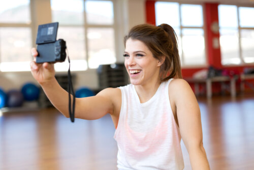 Fille s'enregistrant dans la salle de sport pour devenir l'une des meilleures youtubeuses.