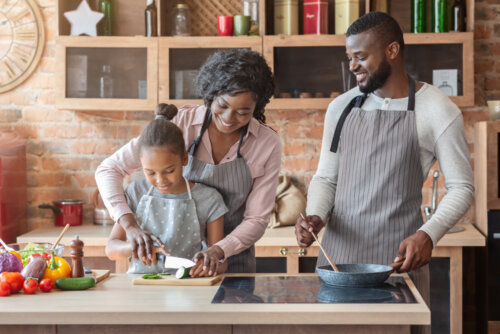 Des parents qui cuisinent avec leur fille.