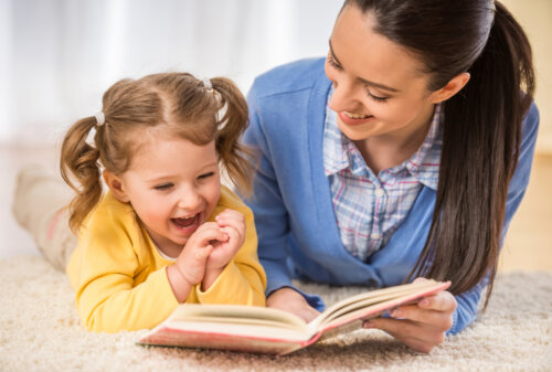 Madre leyendo a su hija un cuento para enseñar a los niños a dormir solos.