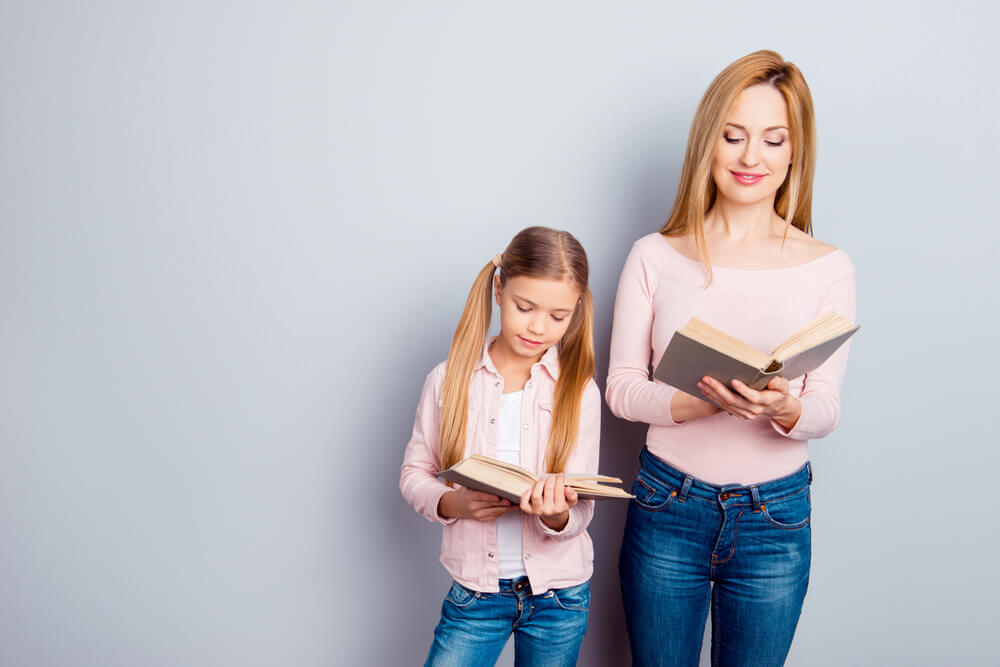 A mother and daughter reading books.