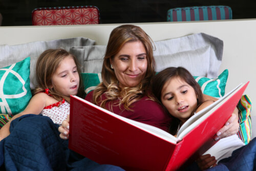 Madre leyendo a sus hijas cuantos para enseñar a los niños a dormir solos.