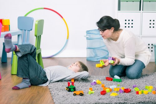 Madre intentando que su hijo recoja los juguetes de su habitación.