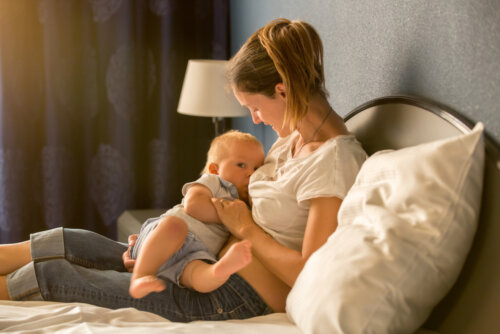 Une maman qui allaite son bébé au lit.