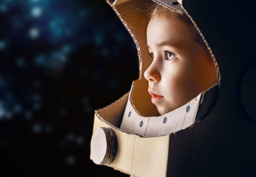 Niña con un casco de astronauta hecho con cartón después de haber leído algunos de los libros infantiles para pequeños astronautas.