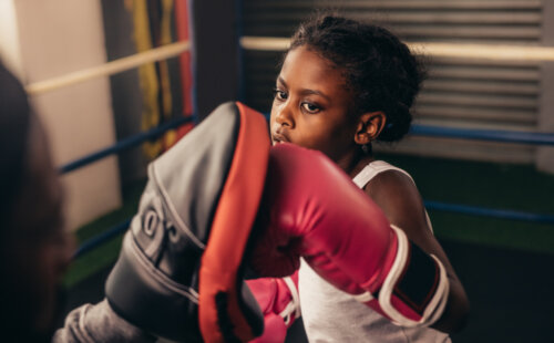 Niña entrenando boxeo, uno de los deportes de combate más conocidos.