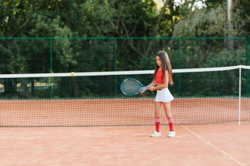 Niña jugando al tenis tras haber leído algunos libros infantiles sobre deporte.
