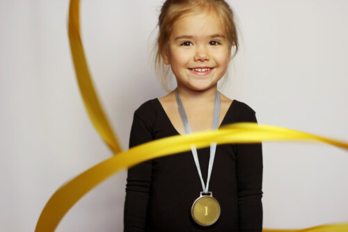 Niña con una medalla de gimnasia rítmica tras haber leído algunos libros infantiles sobre las Olimpiadas.