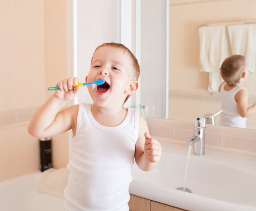 Niño contento mientras aprender a lavarse los dientes.