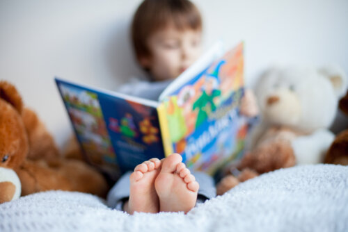 Niño leyendo en la cama uno de los cuentos infantiles para desmontar los estereotipos de género.