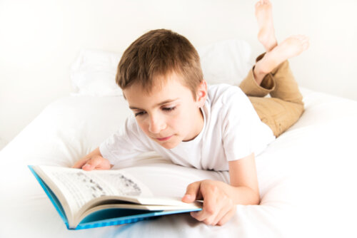 Niño leyendo uno de los libros de la Serie Roja de El Barco de Vapor en su cama.